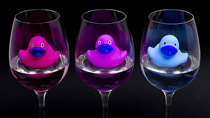 Image showing Pink, purple and blue rubber ducks in wineglasses