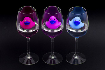 Image showing Pink, purple and blue rubber ducks in wineglasses