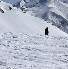 Image showing Ski trail and snowboarder in sun winter day