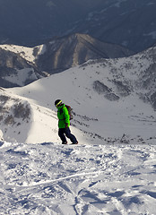 Image showing Snowboarder on off-piste slope in sun evening