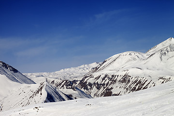 Image showing Ski slope and snowy mountains in sun day