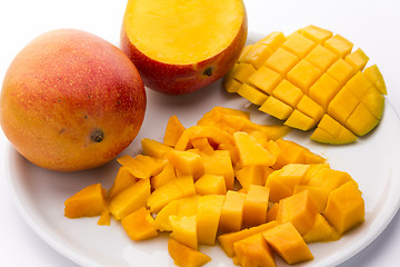 Image showing Heap Of Juicy Mango Cubes And Whole Fruit On Plate