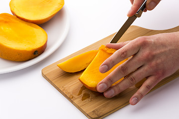 Image showing Juicy Fruit Chip Being Sliced Off A Mango Third