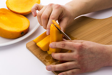 Image showing Peeling Off The Fruit Flesh From The Mango Skin