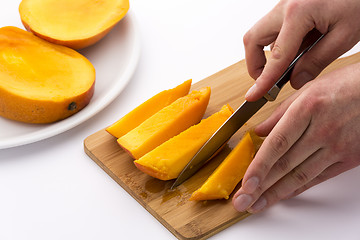 Image showing Knife Finished Cutting Off A Fourth Mango Chip