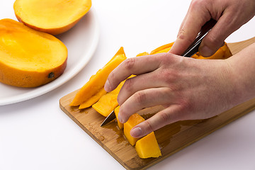 Image showing Mango Wedges Being Diced On A Wooden Cutting Board