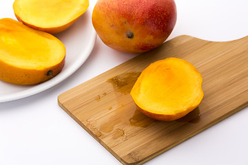 Image showing Juicy Mango Slice On A Wooden Cutting Board