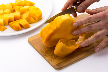 Image showing Middle Third Of A Mango With Its Pit Being Peeled