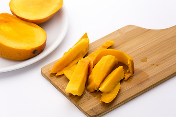 Image showing Mango Fruit Pulp And Its Peel On A Cutting Board