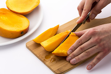 Image showing Mango Divided Into Thirds Being Subdivided Further