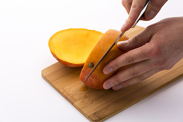 Image showing Knife Positioned For A Second Cut Through A Mango