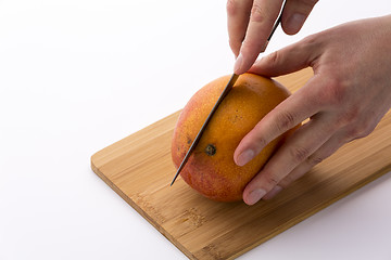 Image showing Kitchen Knife Sinking Into Mango For A First Cut