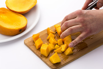 Image showing Juicy Mango Fruit Pulp Diced On A Kitchen Board