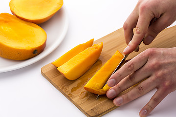 Image showing Mango Slice Being Cut Into Four Fruit Chips