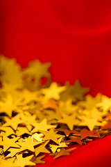 Image showing Gold stars on red fabric. macro