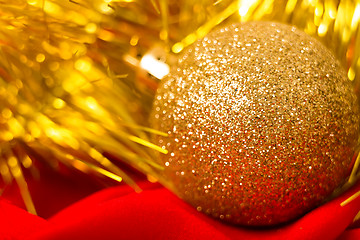 Image showing Christmas golden ball and tinsel on red. macro