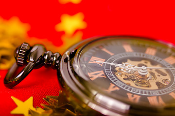 Image showing Christmas card. vintage watch on a red background with golden de