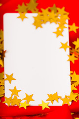 Image showing Golden stars and white card on red cloth. macro