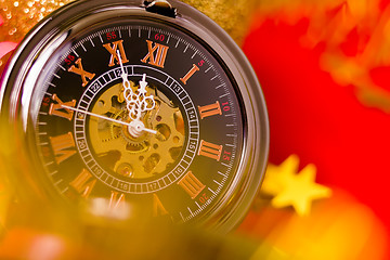 Image showing Christmas card. vintage watch on a red background with golden de