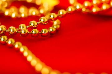 Image showing Gold beads on red fabric. macro