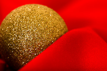 Image showing Christmas golden ball on a red. macro