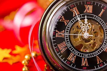 Image showing Christmas card. vintage watch on a red background with golden de