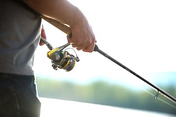 Image showing Modern clean fishing rod in hands