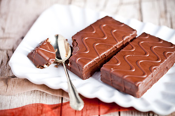 Image showing dark chocolate cakes and spoon on a plate 