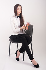 Image showing Attractive businesswoman with cash sits on chair