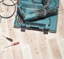 Image showing Electric drill on wooden floor