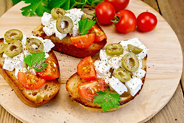 Image showing Sandwich with feta and olives on round board