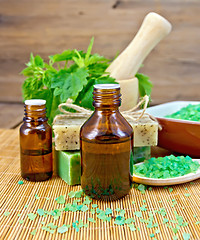 Image showing Oil and soap with nettles in mortar on board