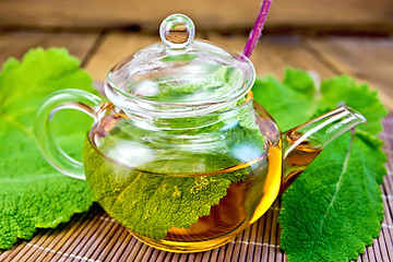 Image showing Tea with sage in teapot on bamboo napkin