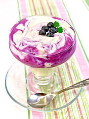 Image showing Dessert milk with blueberries on striped tablecloth