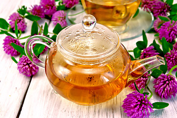 Image showing Tea with clover in glass teapot on light board