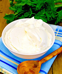 Image showing Yogurt in white bowl with greens on board