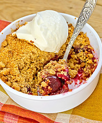 Image showing Crumble cherry in bowl with ice cream on napkin