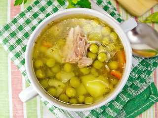 Image showing Soup of green peas with meat on tablecloth