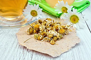 Image showing Chamomile dried on paper with glass cup