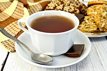 Image showing Tea in white cup with different cookies on light board