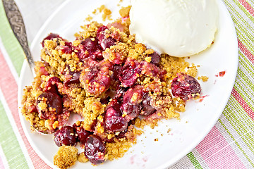 Image showing Crumble cherry in plate with spoon on tablecloth