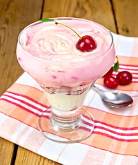 Image showing Dessert milk with cherry and spoon on board