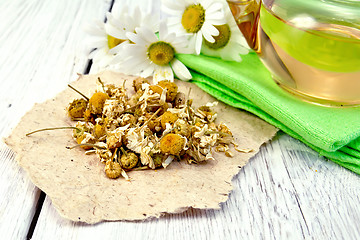 Image showing Chamomile dried on paper with glass teapot