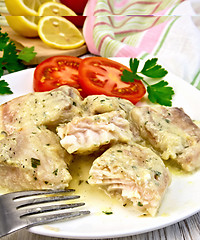 Image showing Fish stew in creamy sauce with tomatoes in plate on board