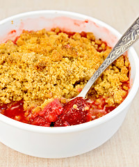 Image showing Crumble strawberry with spoon on fabric