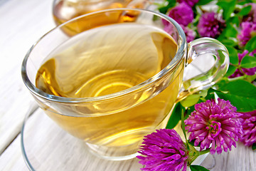 Image showing Tea with clover in cup on light board