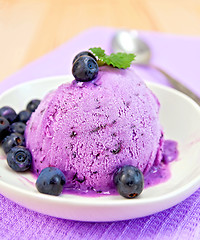 Image showing Ice cream blueberry with mint in dish on napkin