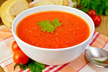 Image showing Tomato soup in bowl on napkin with bread