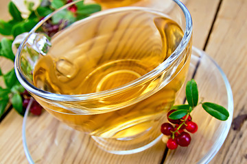 Image showing Tea with lingonberry in glass cup on board