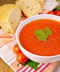 Image showing Tomato soup in bowl with bread on napkin